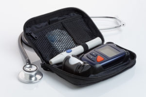 A diabetic blood test kit, or glucometer, in a case. Close up. Logos removed.